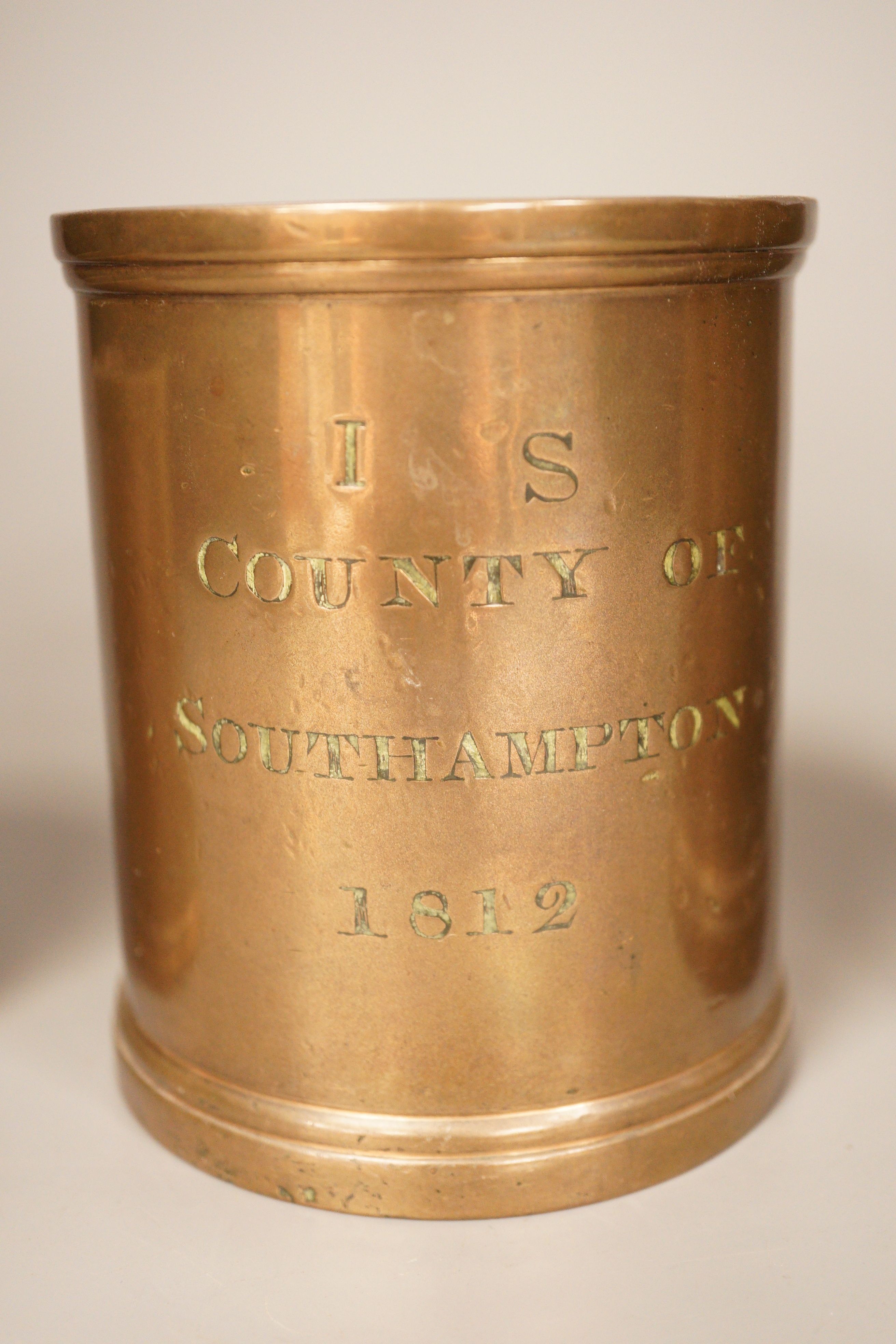 Three early 19th century graduated bronze measures, the larger marked ‘quart Winchester’, the others marked ‘County of Southampton, 1812 (3). 17cm
